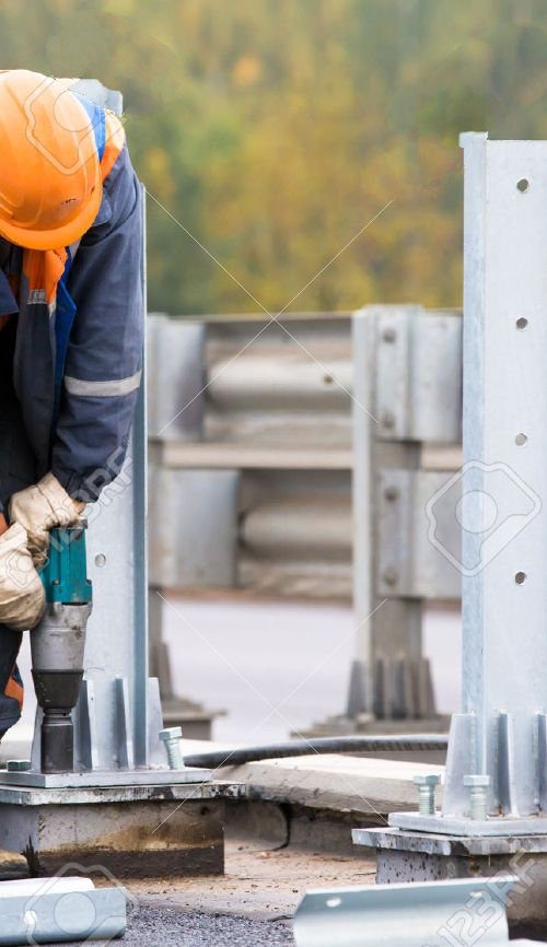 22401659-laborer-worker-tightening-bolts-with-electric-impact-wrench-tool-during-construction-road-works-on-i